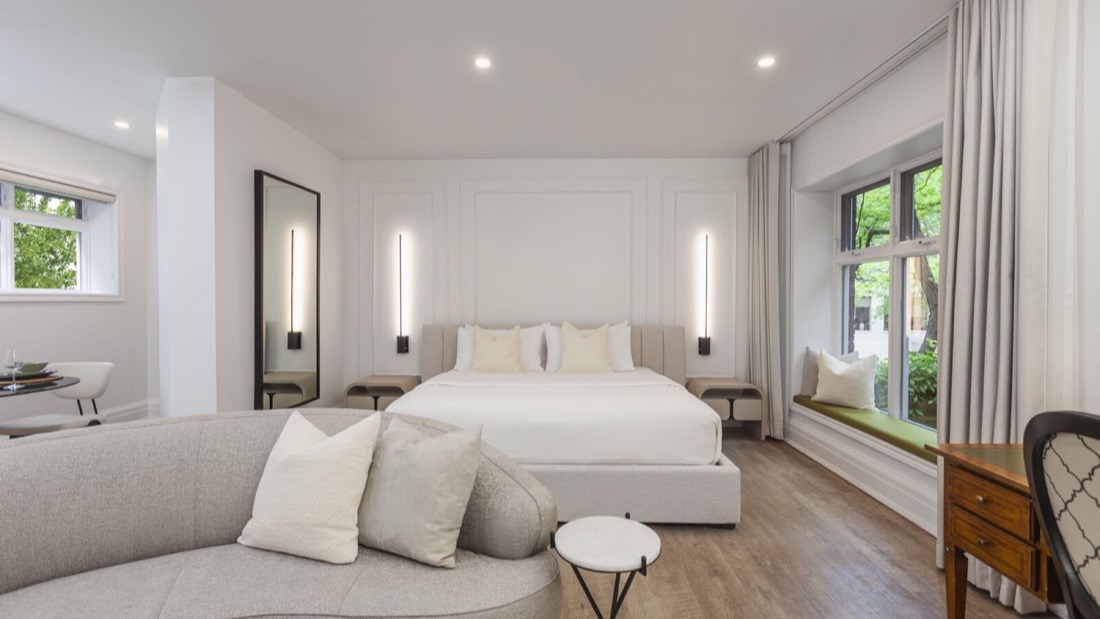 Suite Trianon avec lit king, boiseries blanches et banquette de fenêtre à l’Hôtel du Château Versailles