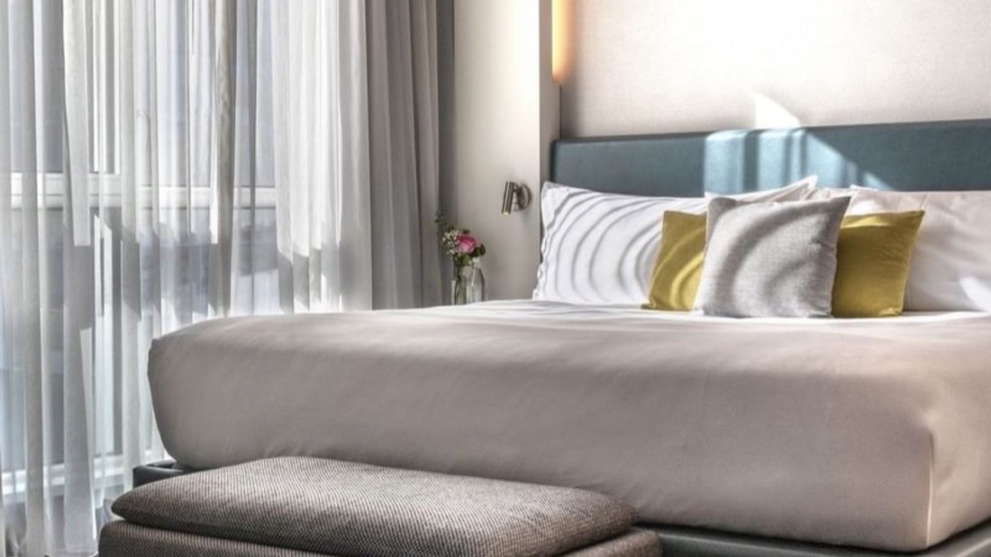 Chambre de la suite loft avec lit king et rideaux voilés au Warwick Le Crystal